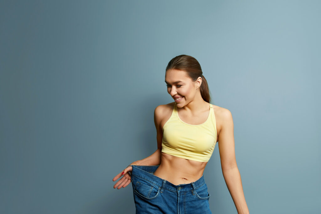 Young woman celebrating weight loss. 