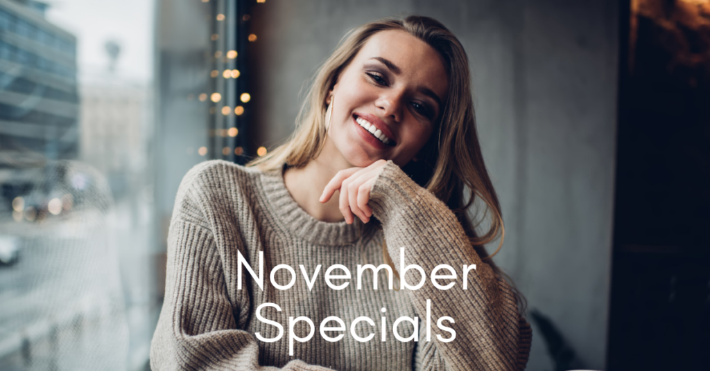 woman in a sweater sitting inside a cafe in the fall and smiling