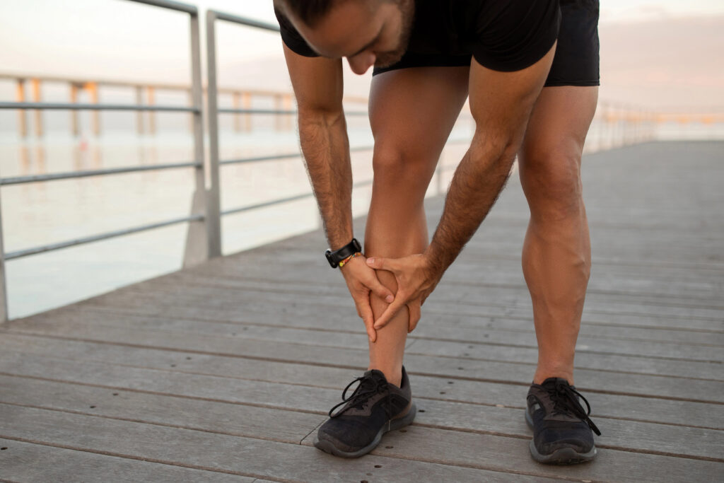 Man outside in summer with leg vein pain.